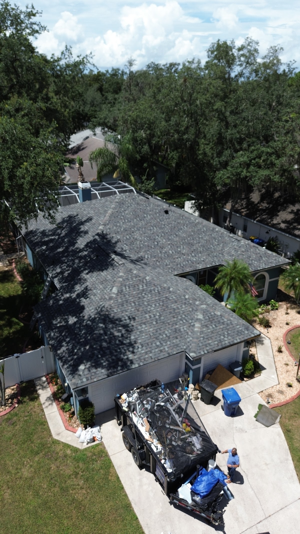 A shingle roof and project cleanup viewed from above.