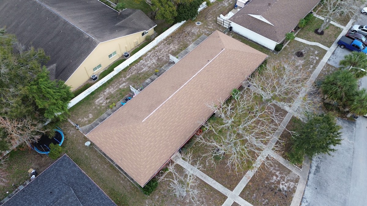 Aerial view of a residential roof with light-colored shingles.